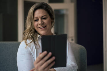 Smiling businesswoman taking selfie through tablet PC in office - JOSEF10247