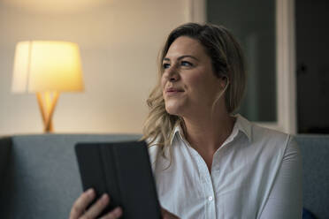 Thoughtful businesswoman with tablet PC at work place - JOSEF10248