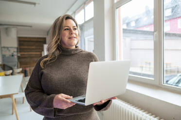 Nachdenklich plus Größe Geschäftsfrau mit Laptop im Büro - JOSEF10270