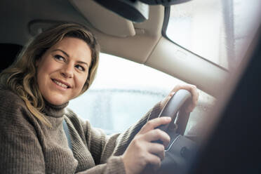 Smiling woman in car on road trip - JOSEF10274