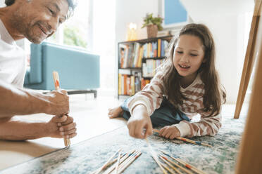 Lächelnder Vater und Tochter spielen Mikado zu Hause - JOSEF10367