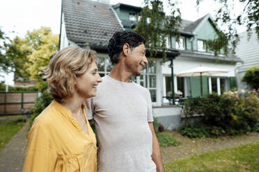 Glücklicher reifer Mann und Frau stehen vor einem Haus - JOSEF10387