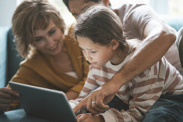 Eltern mit Tochter nutzen Tablet-PC zu Hause - JOSEF10411