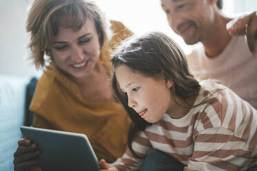 Girl using tablet PC by father and mother at home - JOSEF10412