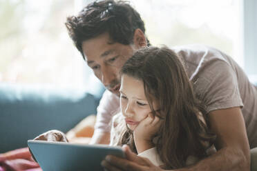 Cute girl with father using tablet PC at home - JOSEF10414