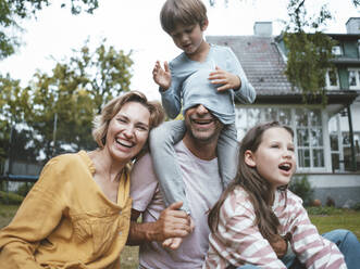 Happy family enjoying together sitting in back yard - JOSEF10444