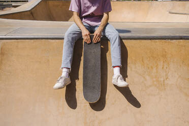 Mann mit Skateboard auf einer Sportrampe an einem sonnigen Tag - MMPF00097