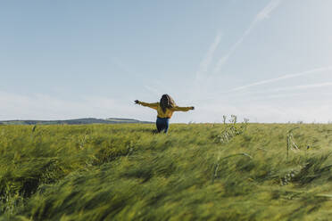 Woman with arms outstretched enjoying in meadow - DMGF00734