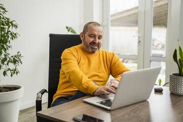 Businessman on video call through laptop at work place - OSF00002