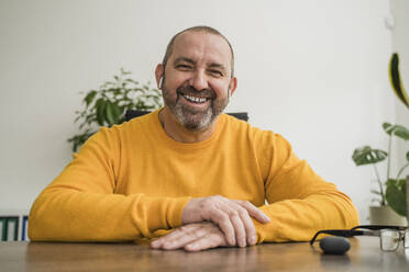 Happy businessman at desk in office - OSF00007