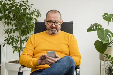 Geschäftsmann Textnachrichten auf Smartphone im Büro - OSF00010