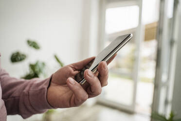 Geschäftsmann hält Smartphone im Büro - OSF00020