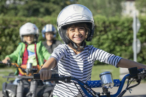 Smiling wearing sports helmet boy riding quadbike at traffic education training - RNF01375