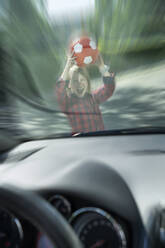Verängstigter Junge mit Ball, der durch die Windschutzscheibe eines Autos versucht, einen Unfall zu verhindern - RNF01387