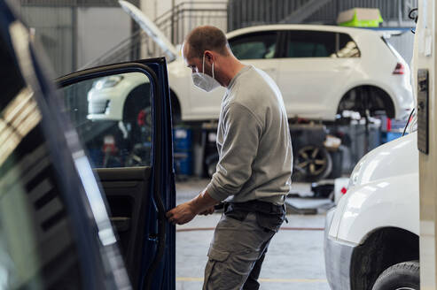 Automechaniker bei der Arbeit an einer Autotür in der Werkstatt - PGF01098