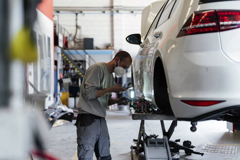 Mechaniker fotografiert Autoteil in der Werkstatt - PGF01102