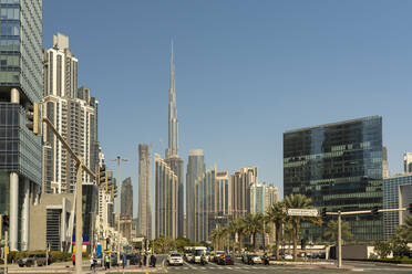 United Arab Emirates, Dubai, Busy street in Business Bay district with tall skyscrapers in background - TAMF03382