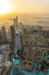 Vereinigte Arabische Emirate, Dubai, Burj Khalifa See und umliegende Wolkenkratzer bei nebligem Sonnenaufgang - TAMF03391