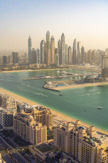 Vereinigte Arabische Emirate, Dubai, Gebäude von Palm Jumeirah mit Yachthafen und Wolkenkratzern im Stadtzentrum im Hintergrund - TAMF03400