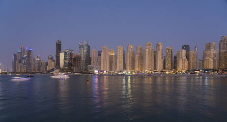 Vereinigte Arabische Emirate, Dubai, Skyline der Küstenwohnungen in der Abenddämmerung - TAMF03416