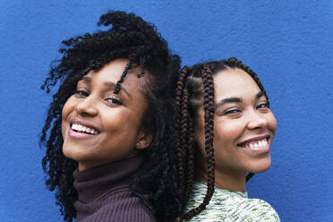 Glückliche Frauen vor einer blauen Wand - PNAF03970