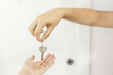Hände eines Immobilienmaklers, der einer Frau einen Hausschlüssel gibt - EGHF00398