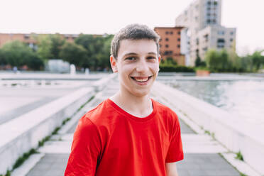 Happy teenage boy wearing red t-shirt - MEUF06126