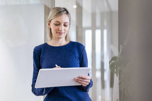 Geschäftsfrau benutzt digitales Tablet im Büro - DIGF17929