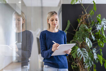 Businesswoman using digital tablet in office - DIGF17930