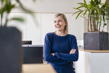 Happy businesswoman laughing in office - DIGF17938