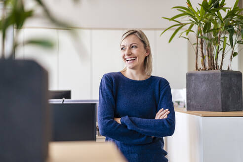 Glückliche Geschäftsfrau lachend im Büro - DIGF17938