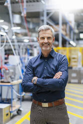 Portrait of confident mature businessman in factory - DIGF17995