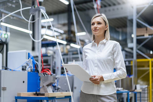 Businesswoman holding digital tablet in factory - DIGF17997