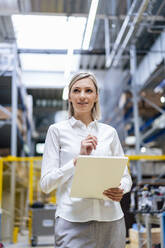 Geschäftsfrau mit digitalem Tablet in einer Fabrik - DIGF18000