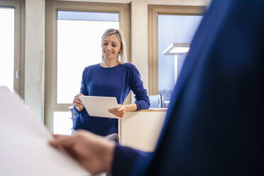 Lächelnde Geschäftsfrau mit digitalem Tablet im Büro - DIGF18071