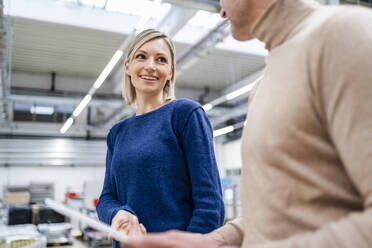 Businessman and businesswoman talking in factory - DIGF18075