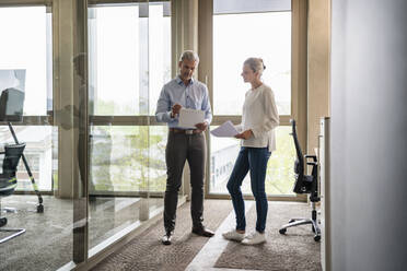 Businessman and businesswoman talking in office - DIGF18087