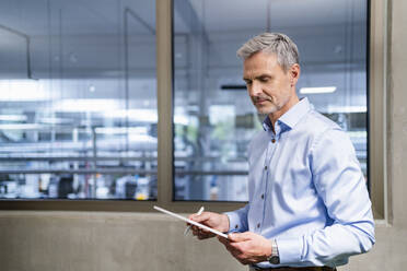 Geschäftsmann mit digitalem Tablet in einem Fabrikbüro - DIGF18106