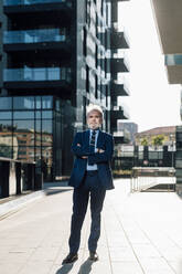 Senior businessman posing with arms crossed outside office building - MEUF06299