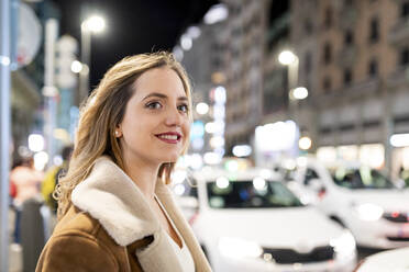 Smiling woman in city at night - WPEF05968