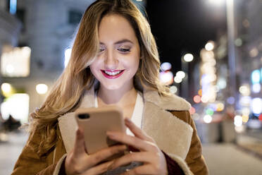 Smiling woman text messaging on smart phone - WPEF05971