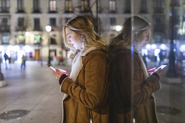 Junge Frau benutzt Smartphone in der Stadt - WPEF05984