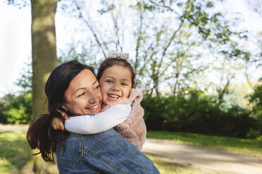 Happy mother and daughter enjoying in park - IHF00886