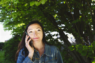 Frau spricht mit Smartphone im Park - IHF00892