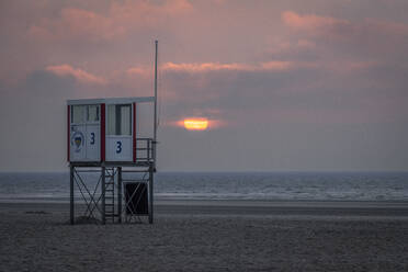 Rettungsschwimmerhäuschen am leeren Strand bei Sonnenuntergang - KEBF02306