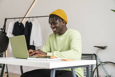 Lächelnder Geschäftsmann bei der Arbeit am Laptop im Home Office - VPIF06422