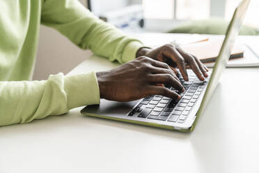 Junger Geschäftsmann tippt am Laptop am Schreibtisch - VPIF06428