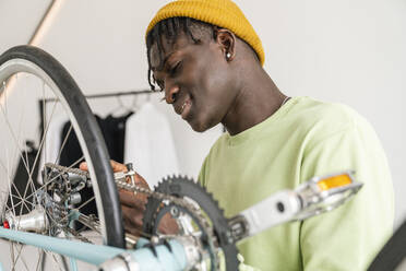 Man adjusting bicycle chain at home - VPIF06439