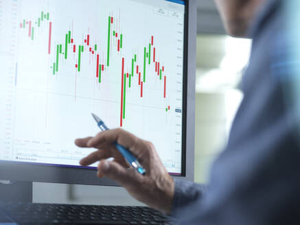Börsenmakler, der den Aktienkurs am Computer im Büro analysiert - ABRF00980