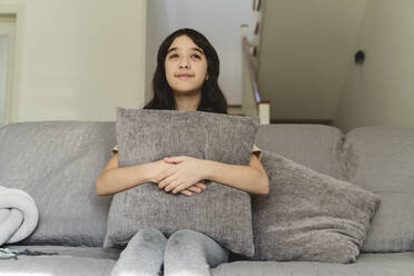 Mädchen träumt auf dem Sofa sitzend - OSF00051